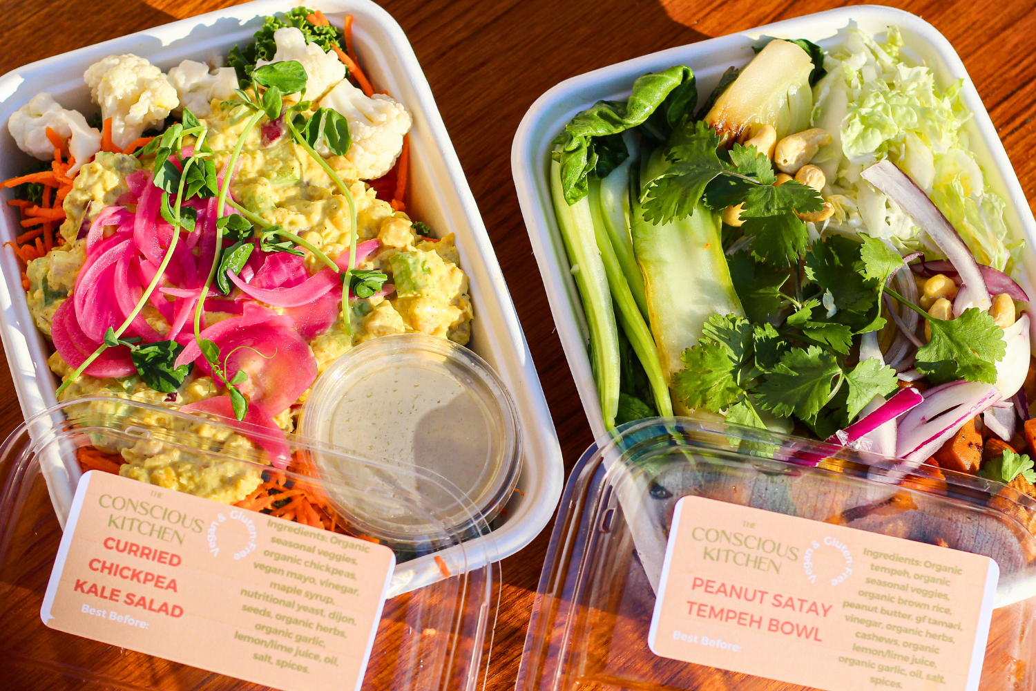 Two of The Conscious Farm Kitchen prepared meals in reusable containers.