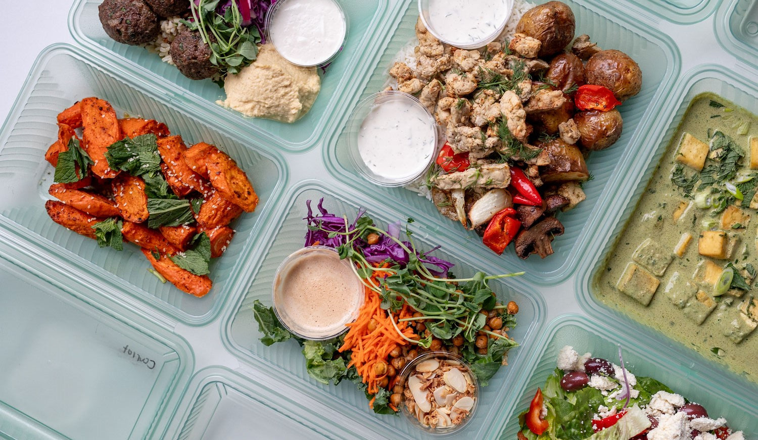 Overhead shot of The Conscious Farm Kitchen prepared meals in reusable containers.