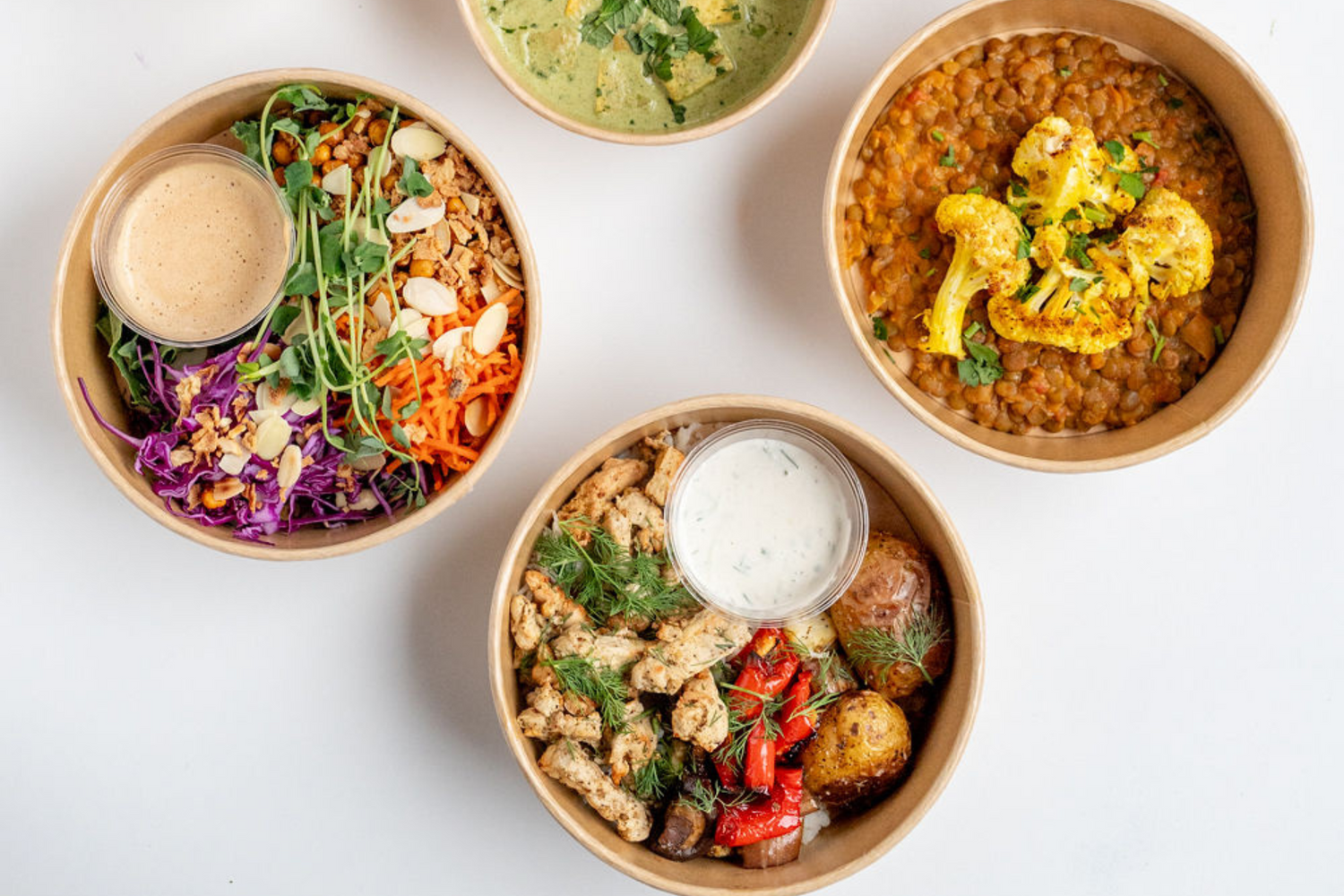 Overhead shot of a selection of The Conscious Farm Kitchen meals in compostable containers.