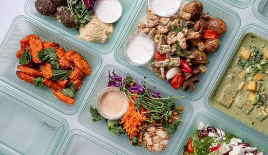 Overhead shot of The Conscious Farm Kitchen prepared meals in reusable containers.